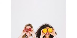 Two happy women having fruits for stress relief