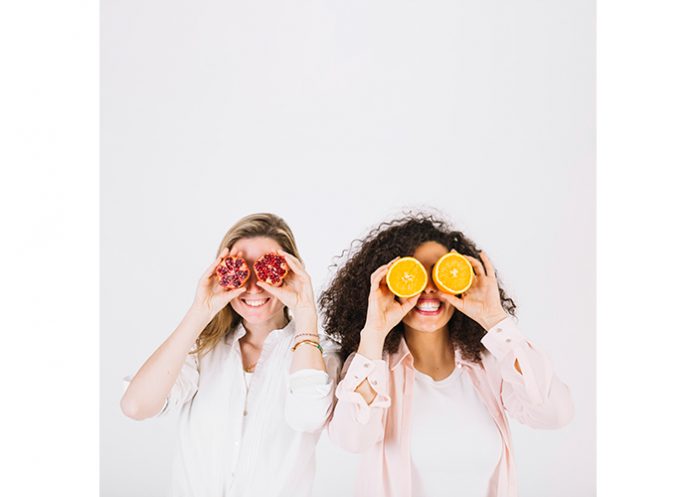 Two happy women having fruits for stress relief