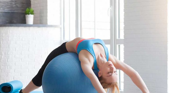 Fit sportswoman doing pilates with stability ball