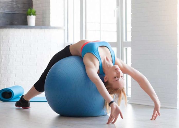 Fit sportswoman doing pilates with stability ball